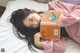 A woman laying on a bed holding a book.