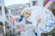 A woman in a white dress holding an umbrella.