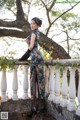 A woman in a blue dress standing on a railing.