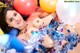 A woman laying on top of a pile of balloons.