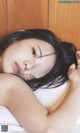 A woman laying on top of a bed with her eyes closed.