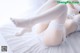 A woman laying on top of a bed wearing white lingerie.